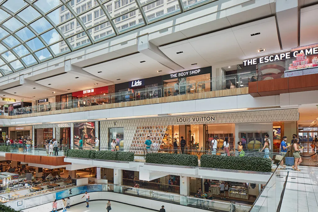 Compradores en outlets en Houston explorando tiendas con grandes descuentos en moda y marcas globales en Texas.