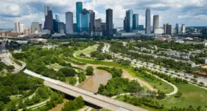 Vista panorámica de Buffalo Bayou Park Houston con senderos verdes y el skyline de la ciudad al fondo.