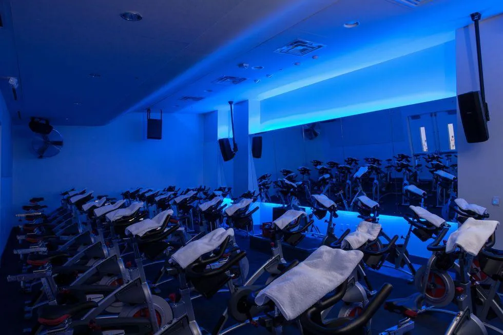 Estudios de cycling en Houston con luces, bicicletas indoor y entrenamiento grupal de alta intensidad en ambiente moderno