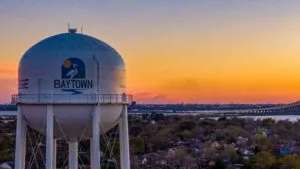 vista panorámica de Baytown Texas al atardecer con torre de agua y puente cercano en el área de Garth Road durante proyecto vial y crecimiento urbano