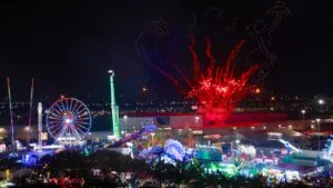 asistentes y juegos mecánicos en el rodeo de Houston con espectáculo nocturno de luces y fuegos artificiales durante evento familiar en Texas