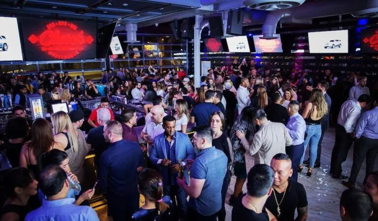 Vida nocturna en Houston con bares iluminados, música y ambiente festivo en Midtown Texas