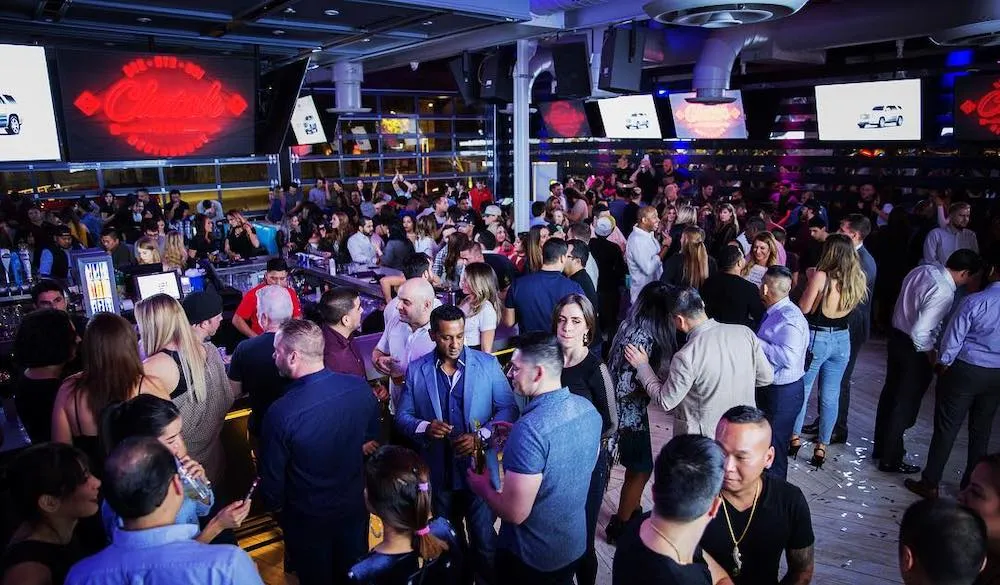 Vida nocturna en Houston con bares iluminados, música y ambiente festivo en Midtown Texas