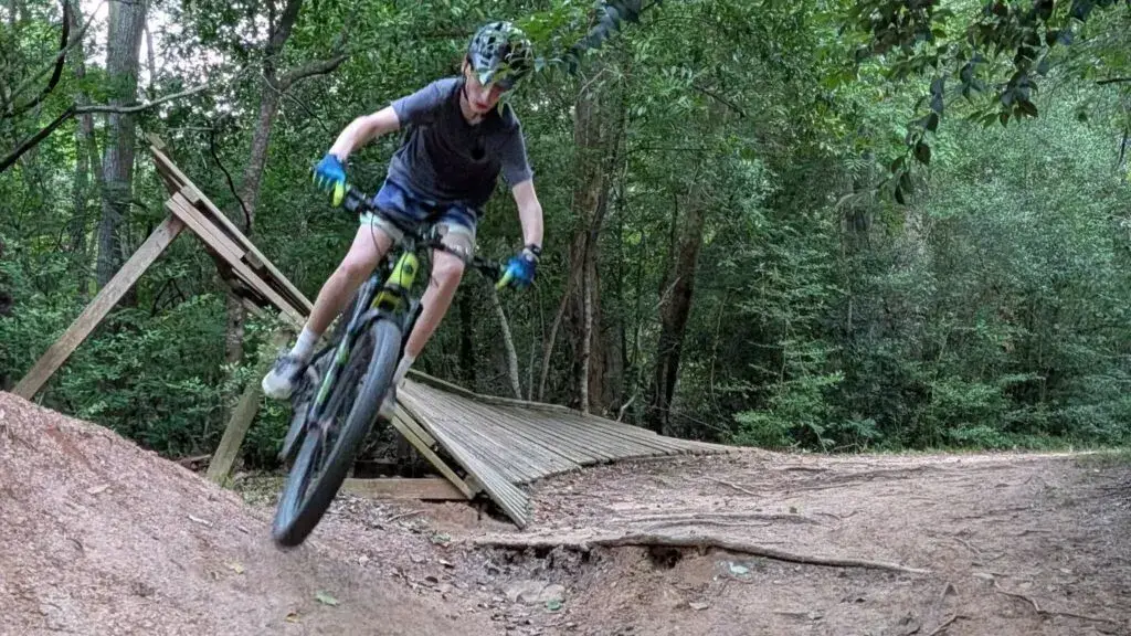 ciclismo de montaña en senderos boscosos de Harris County con estructuras en riesgo de ser removidas