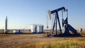petróleo en Texas con refinería y barriles reflejando alza de precios del crudo WTI por tensiones geopolíticas globales
