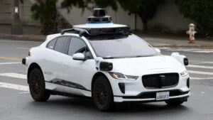 vehículo autónomo de Waymo circulando bajo lluvia intensa en calles urbanas de Texas