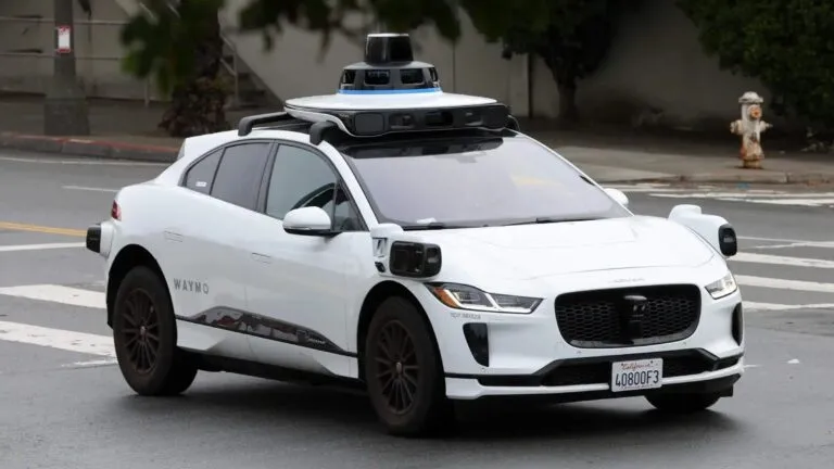 vehículo autónomo de Waymo circulando bajo lluvia intensa en calles urbanas de Texas