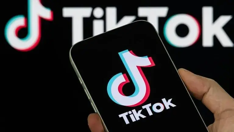 Un adolescente observa videos de TikTok en un teléfono inteligente mientras aparece un mensaje de advertencia sobre retos virales.